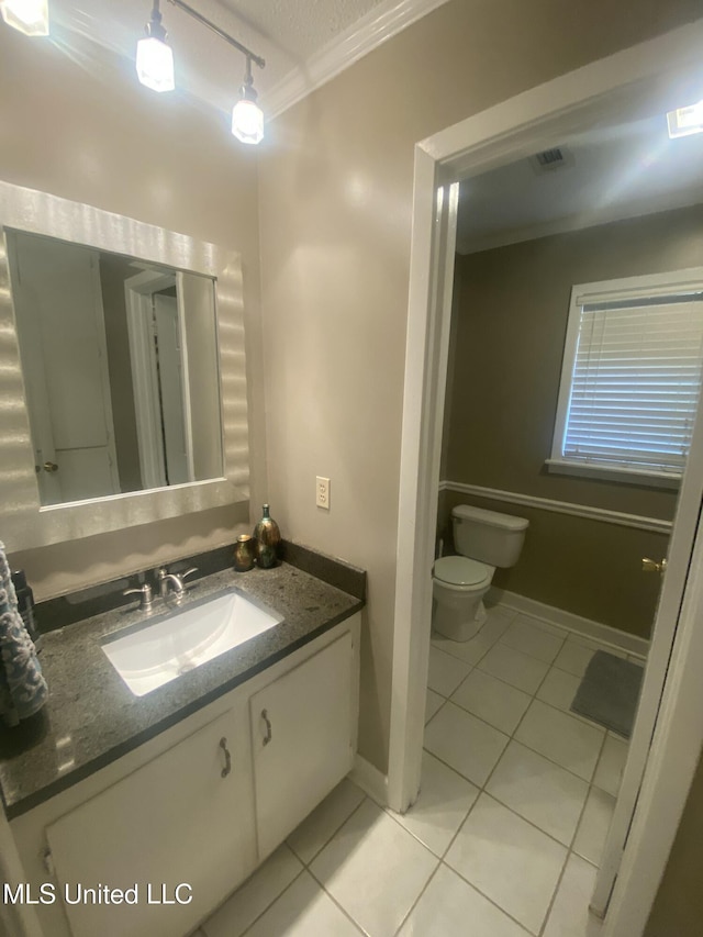 bathroom with visible vents, toilet, tile patterned flooring, crown molding, and vanity