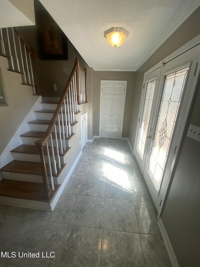 entryway featuring french doors, a textured ceiling, baseboards, and stairs