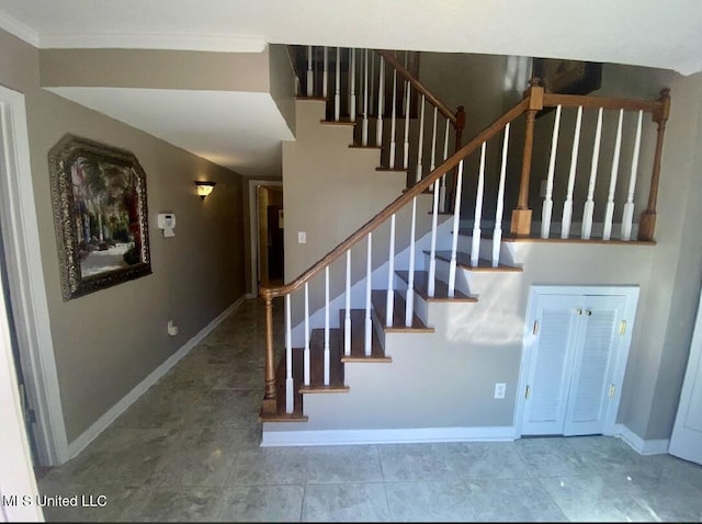 staircase featuring crown molding and baseboards