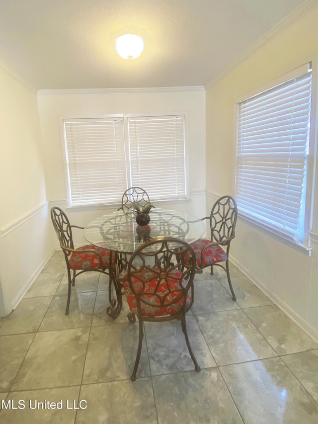 tiled dining area with wainscoting and crown molding