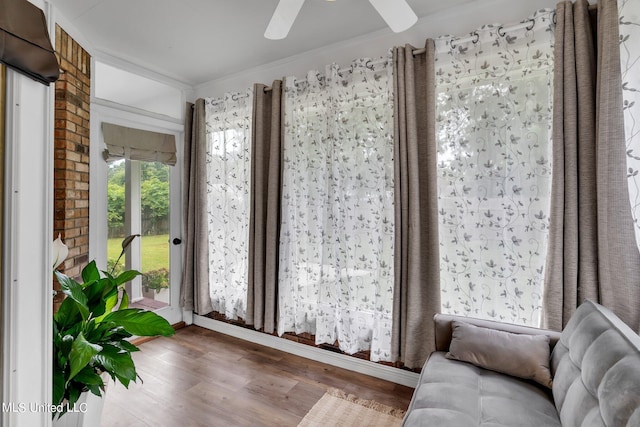 sitting room with hardwood / wood-style floors, crown molding, and ceiling fan