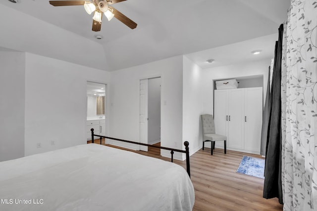 bedroom featuring lofted ceiling, light hardwood / wood-style flooring, ensuite bathroom, and ceiling fan