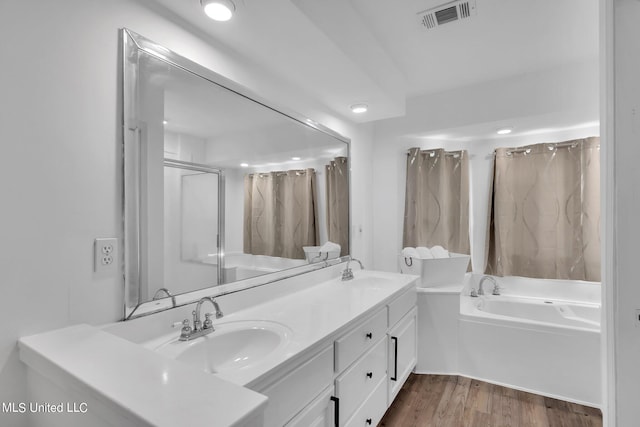 bathroom with vanity, hardwood / wood-style flooring, and plus walk in shower