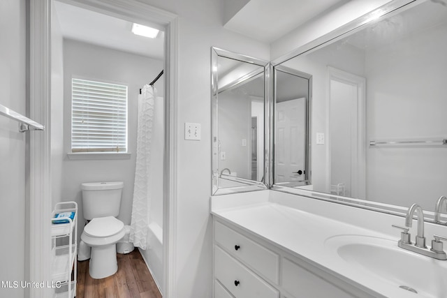 full bathroom featuring toilet, shower / tub combo with curtain, hardwood / wood-style flooring, and vanity