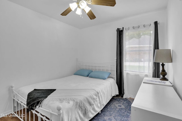 bedroom with dark hardwood / wood-style flooring and ceiling fan