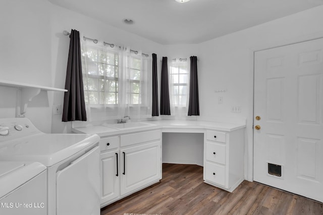 laundry room featuring sink, dark wood-type flooring, washer and clothes dryer, and cabinets