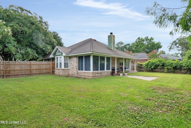 rear view of house featuring a yard and a patio area