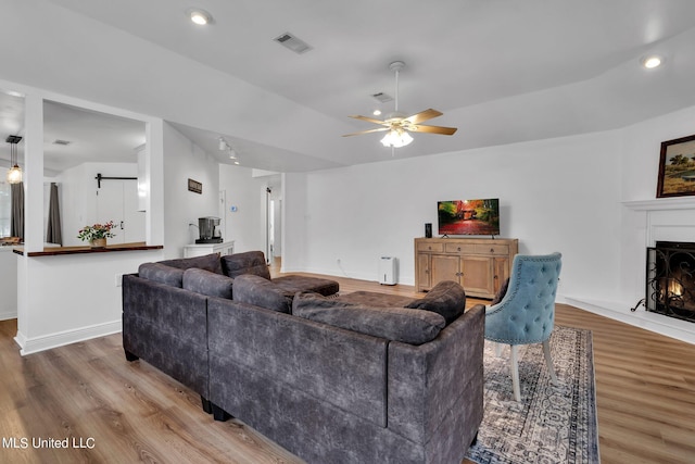 2531 Brighton Cir, Biloxi, MS 39531 - living room with recessed lighting, a warm lit fireplace, wood finished floors, visible vents, and a ceiling fan