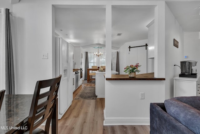 2531 Brighton Cir, Biloxi, MS 39531 - kitchen featuring white refrigerator with ice dispenser, light wood-style floors, white cabinets, a notable chandelier, and visible vents