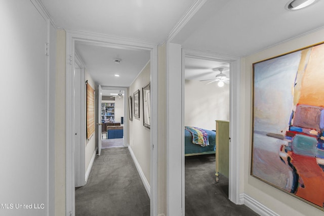 corridor featuring ornamental molding and dark colored carpet