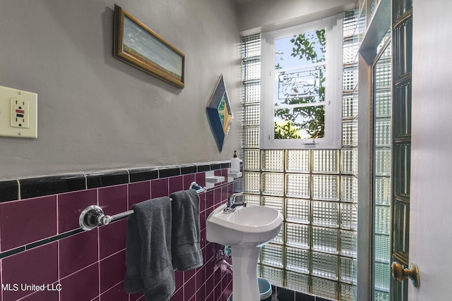 bathroom with tile walls and sink