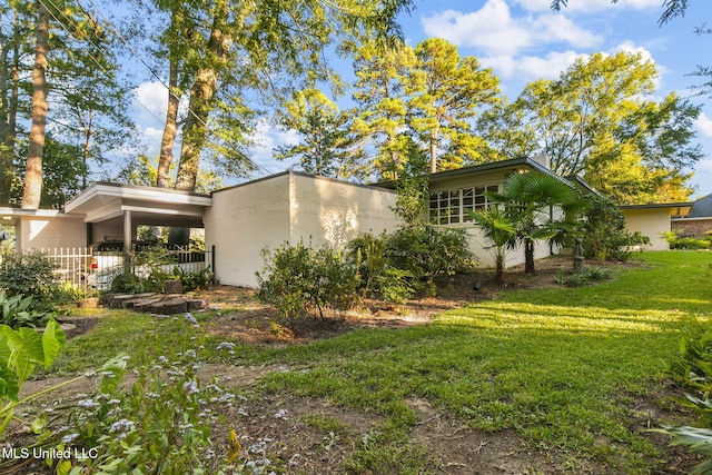 view of home's exterior featuring a yard and a carport