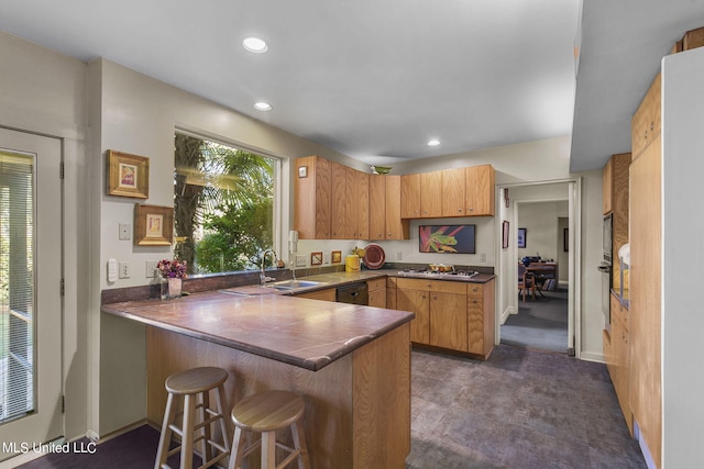 kitchen featuring a breakfast bar, sink, kitchen peninsula, and dishwasher