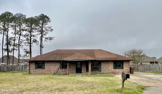 ranch-style home featuring brick siding, a front yard, and fence