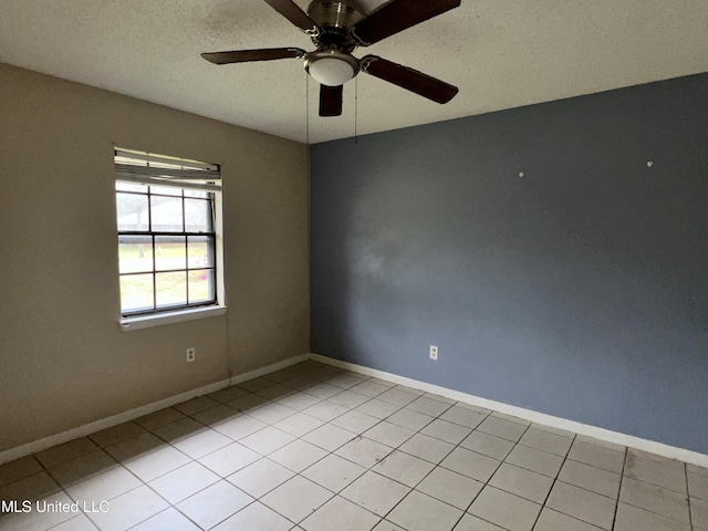 empty room with light tile patterned flooring, baseboards, and a ceiling fan