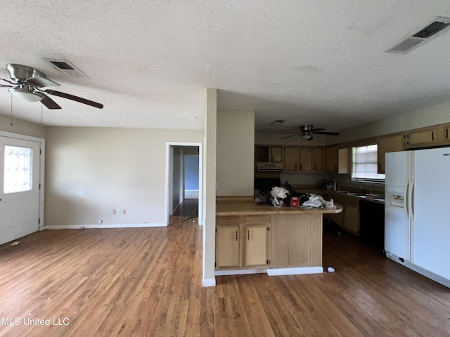 kitchen with wood finished floors, visible vents, white fridge with ice dispenser, and ceiling fan