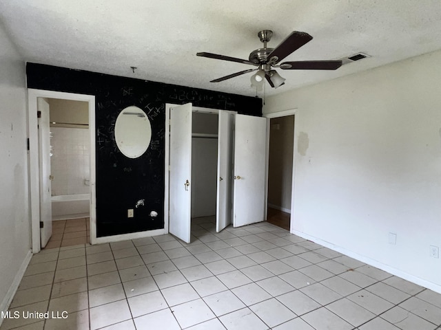 unfurnished bedroom featuring light tile patterned floors, baseboards, visible vents, and a textured ceiling