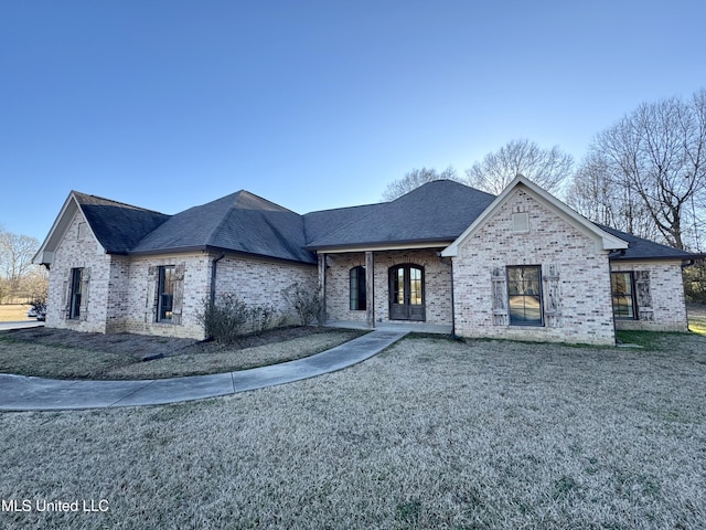 french country inspired facade with a front lawn