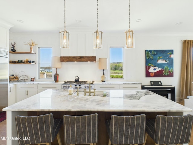 103 Honours Ln, Madison, MS 39110 - kitchen featuring white cabinets, a center island with sink, a breakfast bar, and crown molding