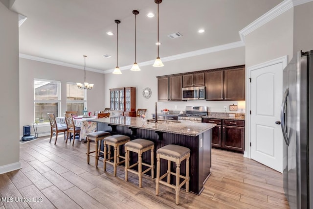 2006 Pelican Cir, Long Beach, MS 39560 - kitchen with stainless steel appliances, a sink, light stone countertops, light wood-style flooring, and a breakfast bar area