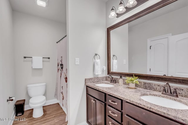 2006 Pelican Cir, Long Beach, MS 39560 - bathroom featuring toilet, wood finished floors, double vanity, baseboards, and a shower with shower curtain