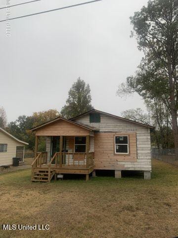 view of front facade with a wooden deck and a front yard