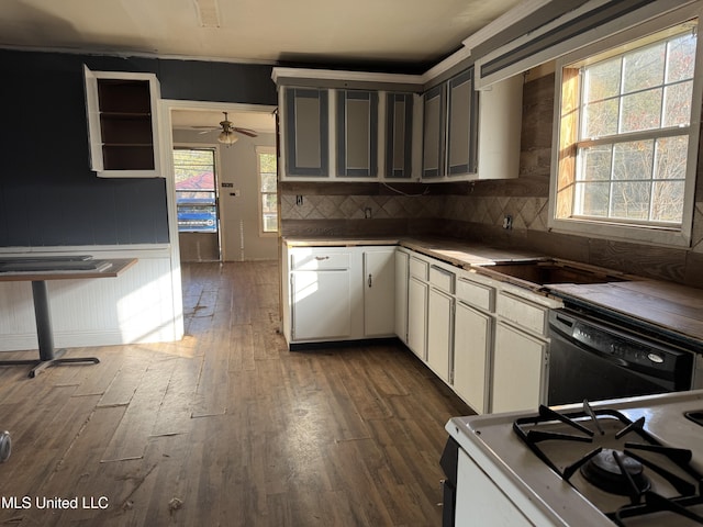 kitchen featuring white gas range oven, white cabinets, dishwasher, dark wood-style flooring, and backsplash