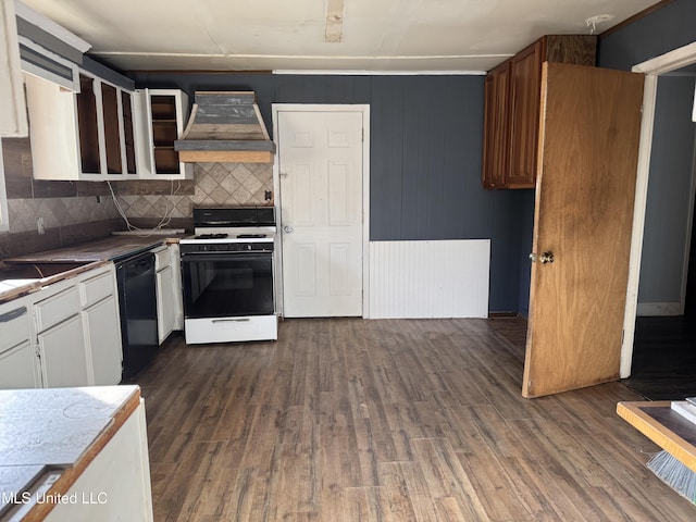 kitchen featuring white range with gas stovetop, premium range hood, black dishwasher, decorative backsplash, and dark wood-style floors