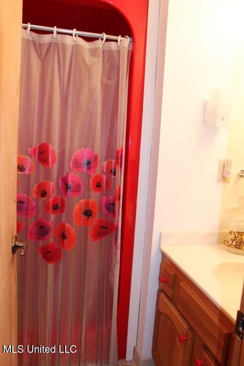 full bathroom with a shower with shower curtain and vanity