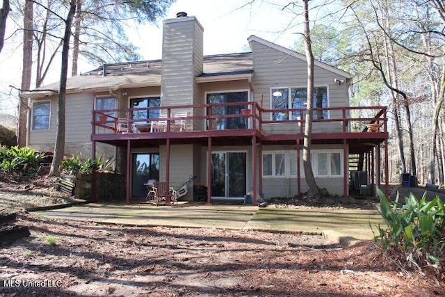 rear view of house with a deck and a chimney