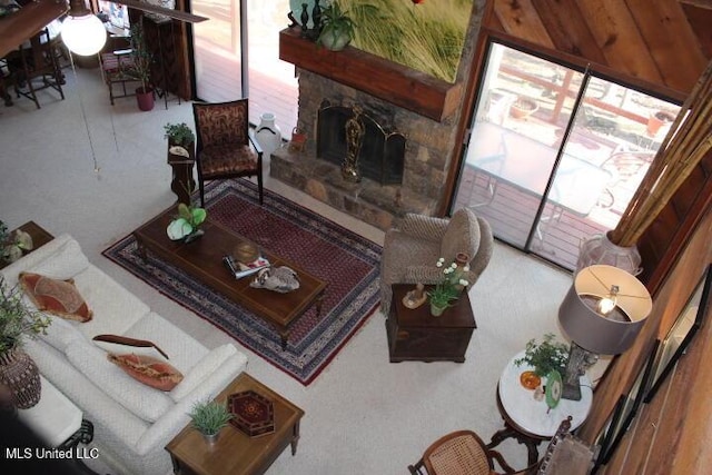 living area featuring a stone fireplace and a healthy amount of sunlight