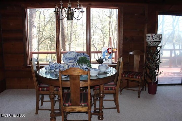 carpeted dining area with a notable chandelier