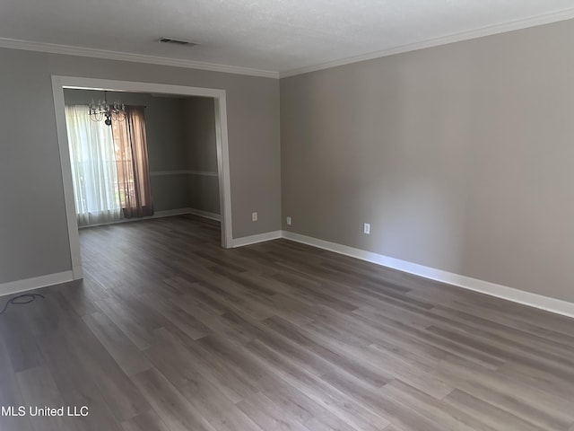903 Westwood St, Pascagoula, MS 39567 - unfurnished room with visible vents, dark wood finished floors, crown molding, and a chandelier