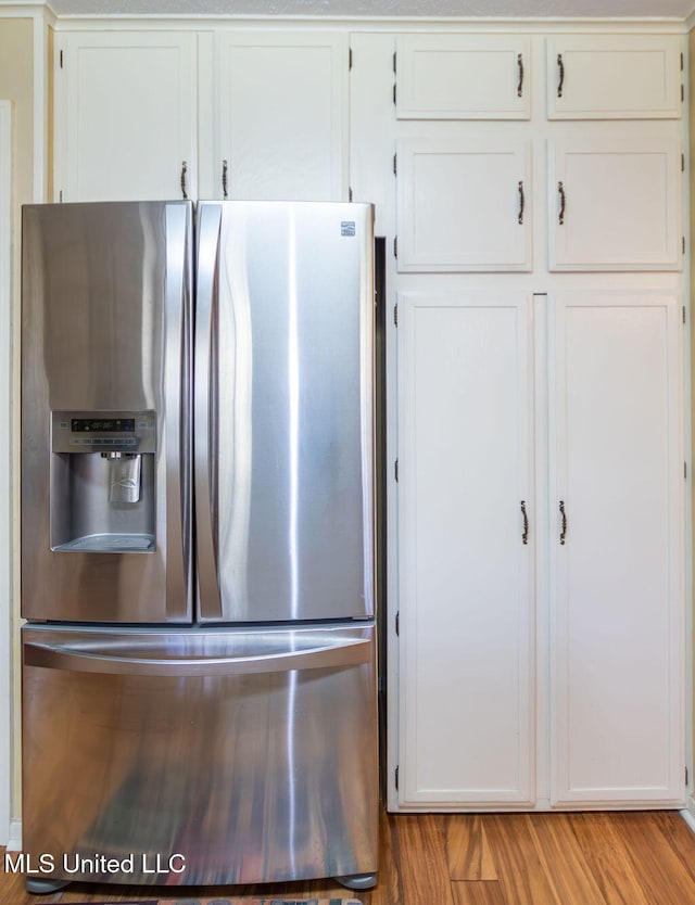 kitchen featuring white cabinetry, stainless steel fridge, and light wood-type flooring