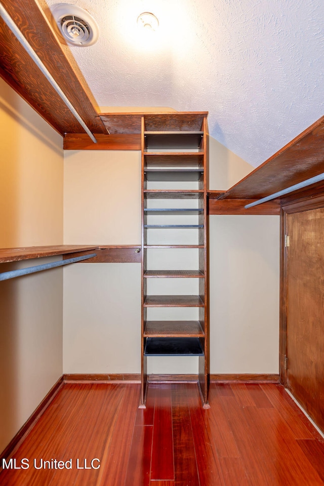 walk in closet with hardwood / wood-style flooring