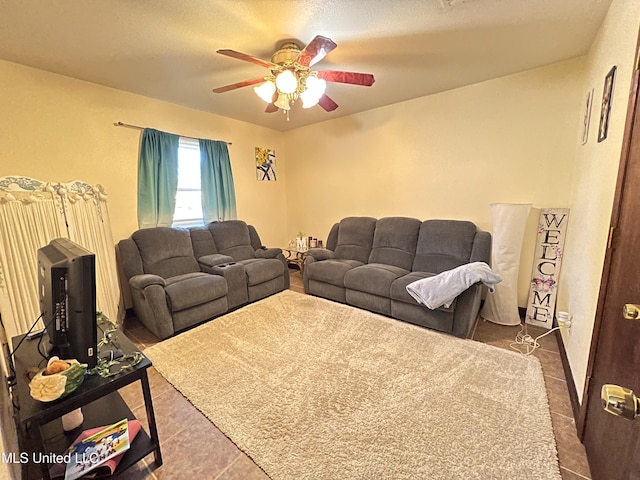 living room with tile patterned flooring, ceiling fan, and a textured ceiling