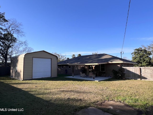 back of property featuring a patio, a yard, and an outdoor structure