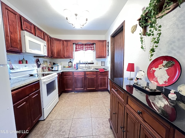 kitchen with sink, an inviting chandelier, light stone counters, white appliances, and light tile patterned floors