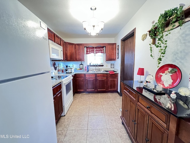 kitchen with white appliances, hanging light fixtures, light tile patterned floors, a notable chandelier, and sink