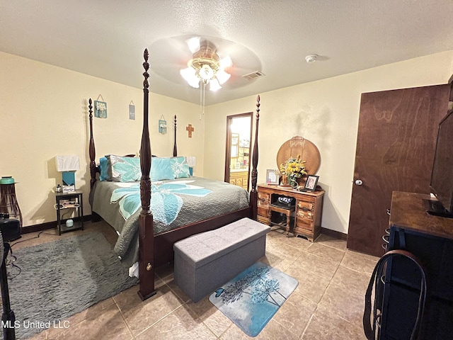 tiled bedroom with ceiling fan and a textured ceiling