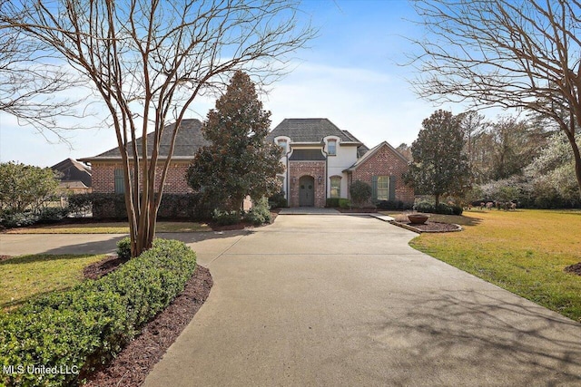 view of front facade featuring brick siding, concrete driveway, and a front lawn