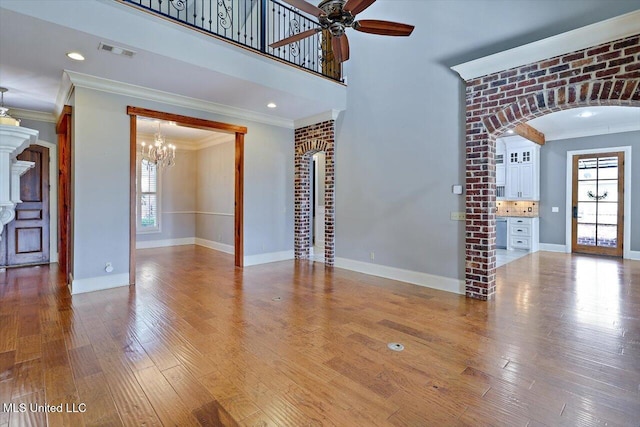 unfurnished living room featuring crown molding, wood finished floors, and a healthy amount of sunlight