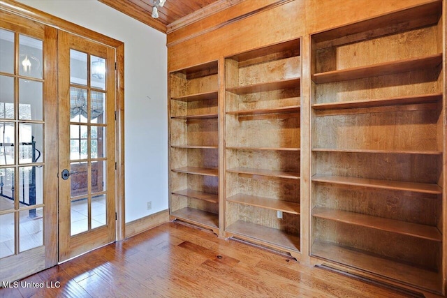 interior space featuring ornamental molding, french doors, wood-type flooring, wooden ceiling, and baseboards