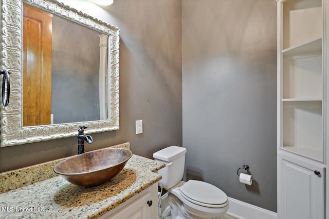 bathroom featuring vanity, toilet, and baseboards