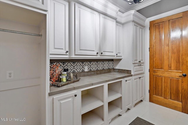 kitchen featuring light tile patterned floors, tile countertops, and white cabinets