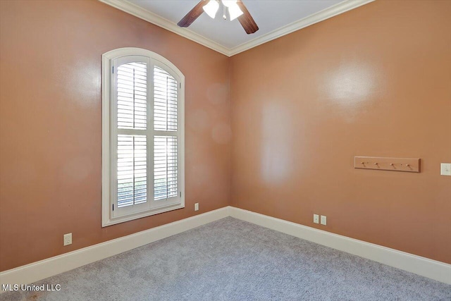 carpeted spare room featuring baseboards, a ceiling fan, and crown molding