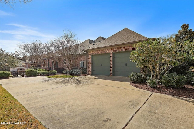 view of front of house featuring brick siding, driveway, an attached garage, and a shingled roof