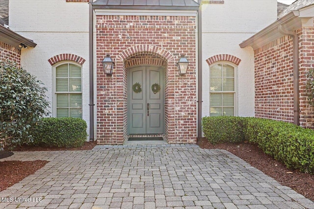 entrance to property featuring brick siding