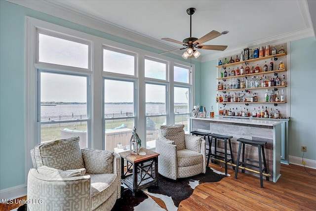 sitting room with crown molding, a dry bar, ceiling fan, and wood finished floors