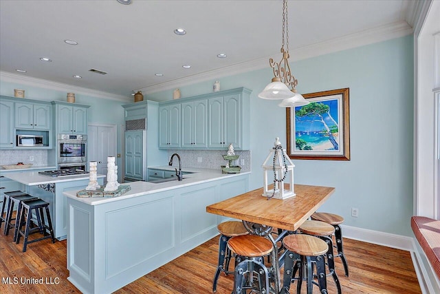 kitchen with decorative backsplash, stainless steel appliances, and light wood-type flooring